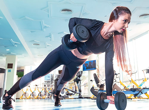 A woman is doing some exercise with dumbbells.